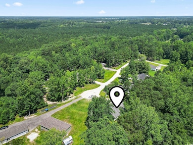 Aerial view of property and surrounding area with a forest