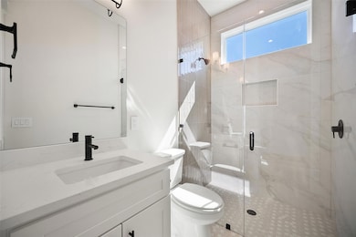 Full bathroom featuring vanity, toilet, and a sho