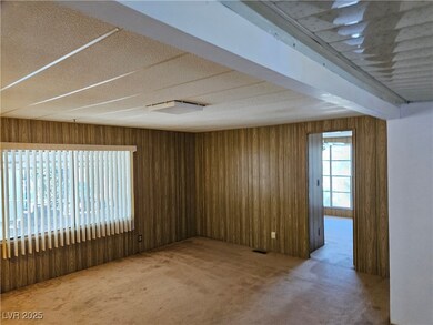 Spare room with carpet flooring, wooden walls, bea