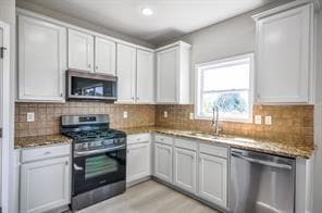 Kitchen featuring white cabinetry, appliances with