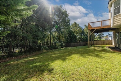 View of yard featuring fence and a wooden deck