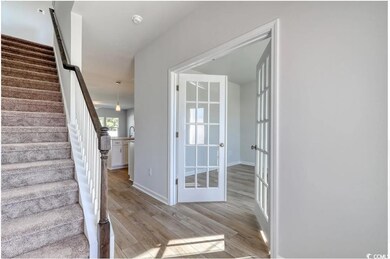 Stairway featuring french doors, hardwood / wood-s