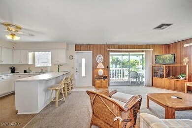 Carpeted living room featuring sink, ceiling fan,