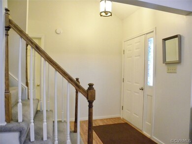 Foyer with hardwood floor, vaulted ceiling
