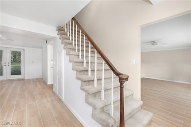 Staircase with french doors and ceiling fan