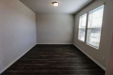 Empty room featuring dark hardwood / wood-style flooring and plenty of natural light