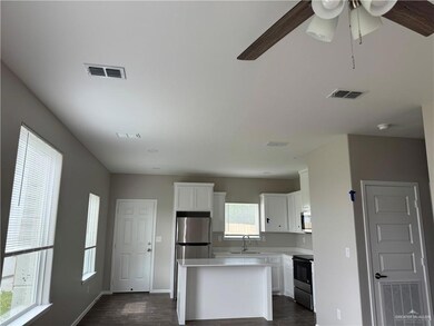 Kitchen featuring a sink, electric range, dark wood-style floors, white cabinets, and light countertops