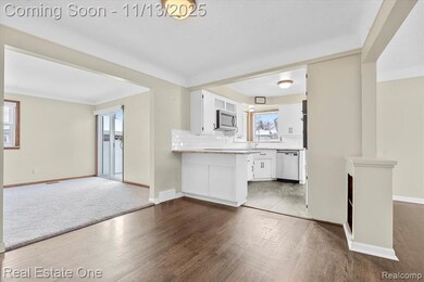Unfurnished living room featuring baseboards and wood finished floors