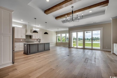 Kitchen with custom range hood, baseboards, a chandelier, recessed lighting, and a sink