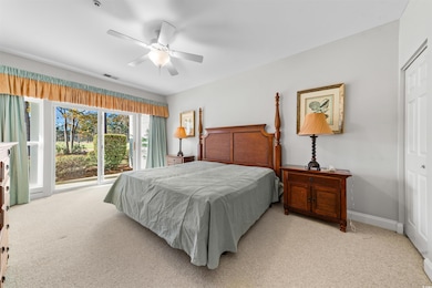 Carpeted bedroom featuring ceiling fan and a close