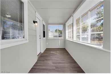 Unfurnished sunroom with wood finished floors and wood walls
