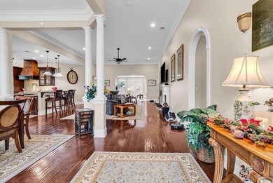 Entrance foyer with decorative columns, a ceiling fan, recessed lighting, and ornamental molding