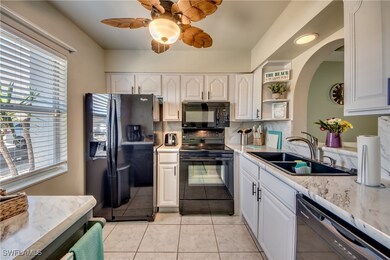 Kitchen with a sink, black appliances, backsplash,
