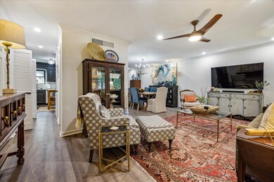 Living room with ceiling fan with notable chandeli