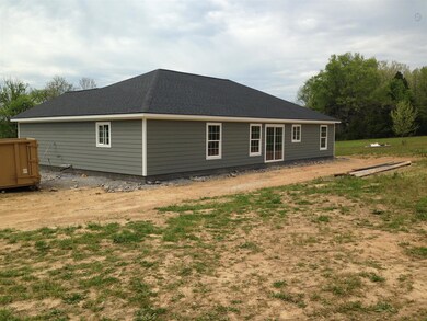 Rear of home with slideing glass door to access kitchen. Patio soon to be poured. Picture is of a similar home.