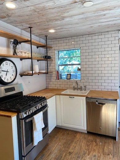 Kitchen featuring stove, wooden counters, dishwas