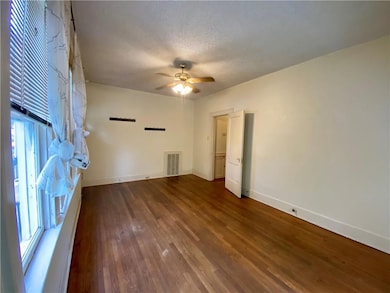 Spare room featuring baseboards, wood finished fl
