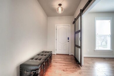Stylish foyer with hardwoods and custom modern bar