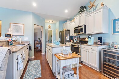 Kitchen with white cabinets, wine cooler, sink, ha