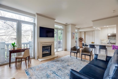 Living room with fire place and tree-top views.