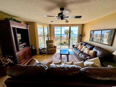 Living room featuring ceiling fan, a textured ceil