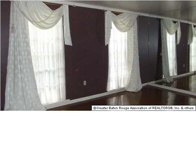 Formal Living Room Has A Wall of Mirrors to Give I