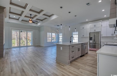 Kitchen featuring a ceiling fan, stainless steel appliances, recessed lighting, light countertops, and open floor plan