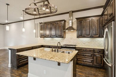 Kitchen with dark brown cabinets, ornamental molding, a peninsula, backsplash, and a breakfast bar area