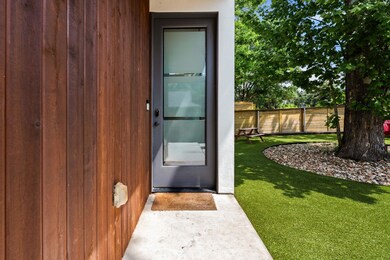 Property entrance featuring fence and a lawn