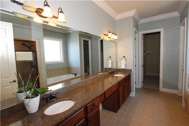 Every home needs a his and hers closet!  This master bath also has a vanity area, granite countertops with undermount sinks and large garage tub.