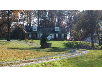 Winding driveway leads to a concrete pad in front 