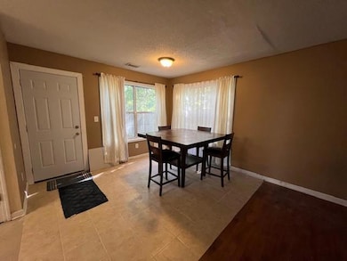 Dining room with baseboards and a textured ceiling