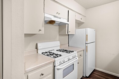 Kitchen with white appliances, light countertops,