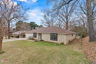 Ranch-style home featuring a front yard and a gara