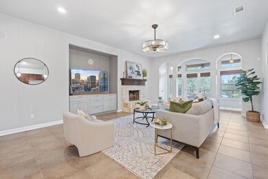 Living area with arched walkways, baseboards, a f