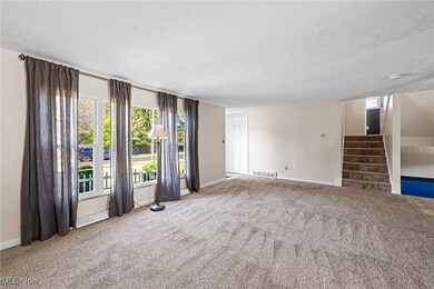 Living room featuring stairway, carpet flooring, and a textured ceiling