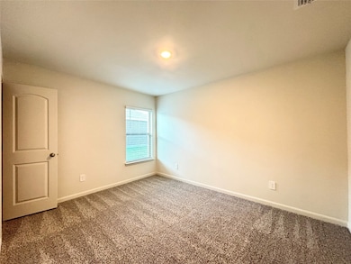 Carpeted empty room featuring baseboards