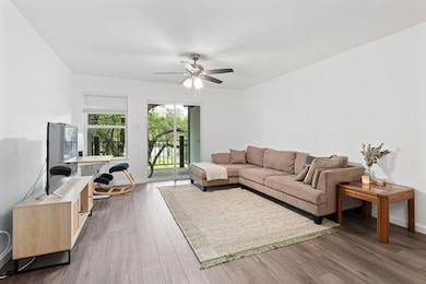 Living room featuring ceiling fan, dark wood-styl
