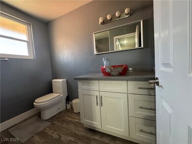 Bathroom with toilet, vanity, wood finished floors