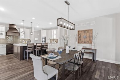 Dining area with dark wood-style flooring and recessed lighting