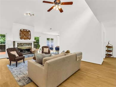 Living room featuring ceiling fan, high vaulted ce