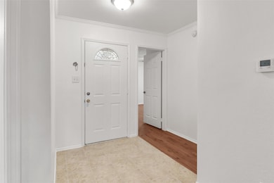 Entrance foyer featuring ornamental molding and li