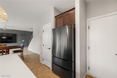 Kitchen with freestanding refrigerator, a ceiling fan, and light tile patterned floors