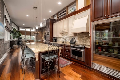 Kitchen with stainless steel electric range, premium range hood, light stone countertops, dark wood-style floors, and recessed lighting