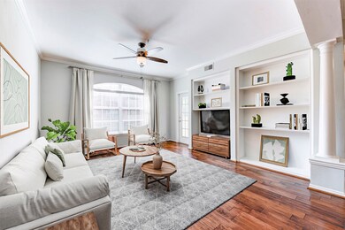Alternate view of the room shows its oversized window with ample natural light, built-in shelves, and a ceiling fan, creating a bright and functional living space.