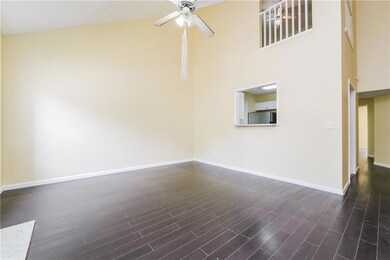 Spare room with a high ceiling, ceiling fan, baseboards, and dark wood-type flooring