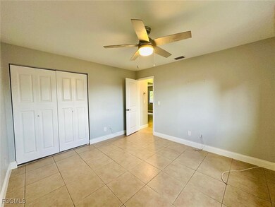 Unfurnished bedroom featuring ceiling fan, a closet, and light tile patterned floors
