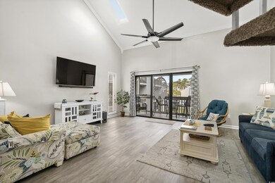 Living room featuring high vaulted ceiling, a skyl