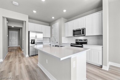 Kitchen with sink, white cabinetry, an island with