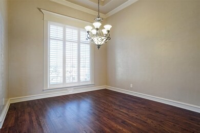 Dining room with cased window frame, custom baseboards, crown molding, oakwood finished floor and an inviting chandelier